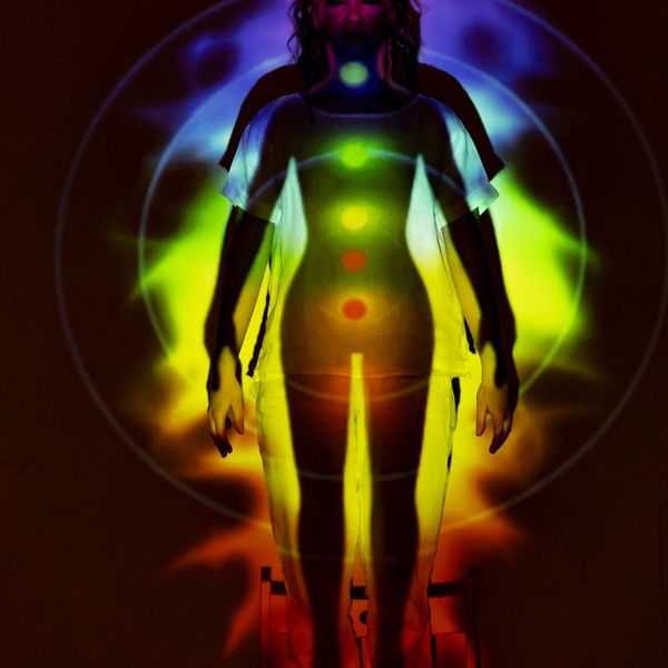 Silhouette of a person meditating with a copper-colored aura.