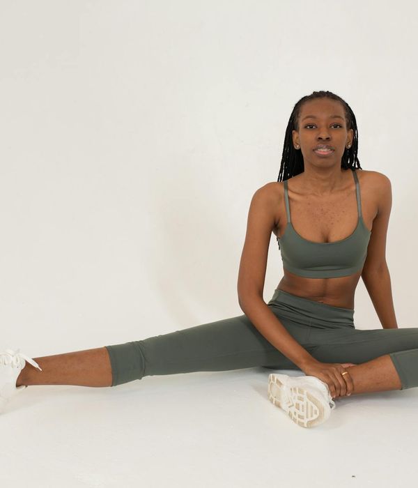 Woman in a peaceful yoga pose against a dark, urban background.
